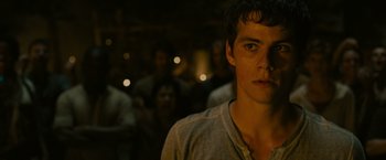 Movie still from “The Maze Runner” (2014), directed by Wes Ball – A young man standing in front of a group of people; Close Up shot, Over the shoulder angle