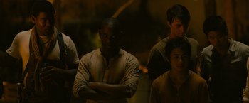 Movie still from “The Maze Runner” (2014), directed by Wes Ball – A group of men standing next to each other in a dark room; Medium shot, Over the shoulder angle