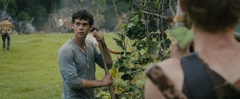 Movie still from “The Maze Runner” (2014), directed by Wes Ball – A young man holding a wooden stick in his hand; Medium shot, Over the shoulder angle