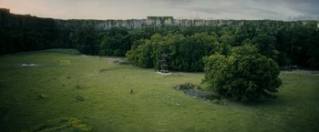 Movie still from “The Maze Runner” (2014), directed by Wes Ball – An aerial view of a park with trees and a pond; Extreme Wide shot, Low angle