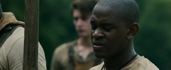 Movie still from “The Maze Runner” (2014), directed by Wes Ball – A man in a brown shirt and a woman in a black shirt; Close Up shot, Over the shoulder angle