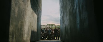 Movie still from “The Maze Runner” (2014), directed by Wes Ball – A large group of people standing in front of a gate; Wide shot, High angle