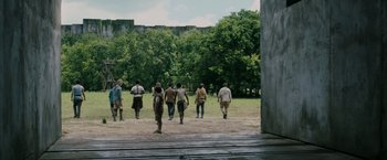 Movie still from “The Maze Runner” (2014), directed by Wes Ball – A group of people walking across a dirt field; Extreme Wide shot, Low angle