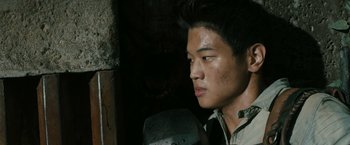 Movie still from “The Maze Runner” (2014), directed by Wes Ball – A young asian man looking to his left; Close Up shot, Over the shoulder angle