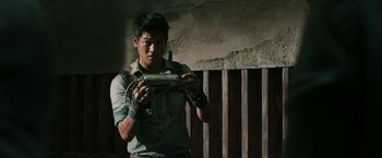 Movie still from “The Maze Runner” (2014), directed by Wes Ball – A man holding a video game controller in his hands; Medium shot, Low angle