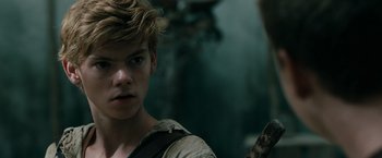 Movie still from “The Maze Runner” (2014), directed by Wes Ball – A young man in a forest with a tree in the background; Close Up shot, Over the shoulder angle