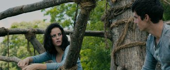 Movie still from “The Maze Runner” (2014), directed by Wes Ball – A woman leaning up against a tree in a wooded area; Close Up shot, Low angle