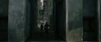 Movie still from “The Maze Runner” (2014), directed by Wes Ball – Two children running down a path in a building; Extreme Wide shot, High angle