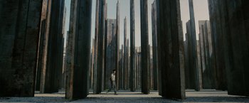Movie still from “The Maze Runner” (2014), directed by Wes Ball – A person is standing in the middle of some pillars; Extreme Wide shot, Low angle