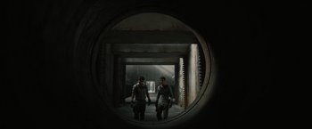 Movie still from “The Maze Runner” (2014), directed by Wes Ball – Two people are walking through an industrial setting; Wide shot, Overhead angle