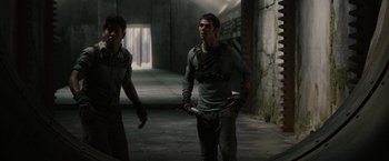 Movie still from “The Maze Runner” (2014), directed by Wes Ball – A man walking down a street with a knife in his hand; Medium shot, Over the shoulder angle