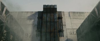 Movie still from “The Maze Runner” (2014), directed by Wes Ball – A building that has a bunch of pipes on the side of it; Extreme Wide shot, Low angle