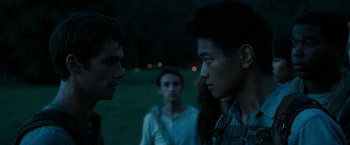 Movie still from “The Maze Runner” (2014), directed by Wes Ball – Two young men standing next to each other on a field; Close Up shot, Over the shoulder angle