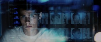 Movie still from “The Maze Runner” (2014), directed by Wes Ball – A young man looking at the camera through a glass window; Close Up shot, Over the shoulder angle