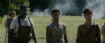 Movie still from “The Maze Runner” (2014), directed by Wes Ball – A young man standing in front of a smoke filled field; Medium shot, Low angle