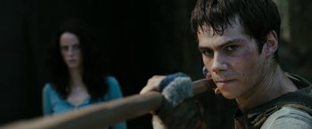 Movie still from “The Maze Runner” (2014), directed by Wes Ball – A young man holding a wooden baseball bat in his hands; Close Up shot, Over the shoulder angle