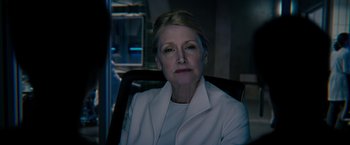 Movie still from “The Maze Runner” (2014), directed by Wes Ball – An older woman wearing a white jacket sitting in an office chair; Close Up shot, Over the shoulder angle