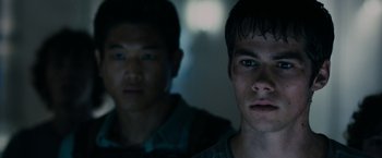Movie still from “The Maze Runner” (2014), directed by Wes Ball – Two young men standing next to each other in a dark room; Close Up shot, Low angle