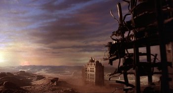 Movie still from “The Meaning of Life” (1983), directed by Terry Jones – An abandoned building in the middle of a desert landscape; Extreme Wide shot, Low angle