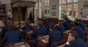 Movie still from “The Meaning of Life” (1983), directed by Terry Jones – A group of young men sitting at desks in a classroom; Wide shot, High angle