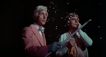 Movie still from “The Meaning of Life” (1983), directed by Terry Jones – A man and a woman standing next to each other; Medium shot, Low angle