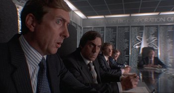 Movie still from “The Meaning of Life” (1983), directed by Terry Jones – A group of men in suits sitting at a table; Medium shot, Low angle