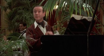 Movie still from “The Meaning of Life” (1983), directed by Terry Jones – A man is playing a piano in a room; Close Up shot, Over the shoulder angle