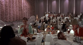 Movie still from “The Meaning of Life” (1983), directed by Terry Jones – A group of people sitting at tables in a banquet hall; Wide shot, High angle
