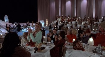 Movie still from “The Meaning of Life” (1983), directed by Terry Jones – A group of people sitting at a dinner table; Wide shot, High angle