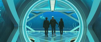 Movie still from “The Meg” (2018), directed by Jon Turteltaub – A group of people standing in front of an aquarium; Wide shot, High angle