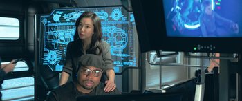 Movie still from “The Meg” (2018), directed by Jon Turteltaub – A man and a woman sitting in front of a computer screen; Medium shot, High angle