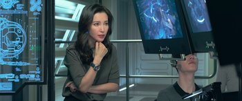 Movie still from “The Meg” (2018), directed by Jon Turteltaub – A woman sitting in front of a television; Close Up shot, Over the shoulder angle