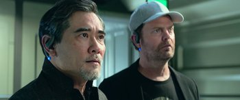 Movie still from “The Meg” (2018), directed by Jon Turteltaub – Two men standing next to each other in front of a wall; Close Up shot, Low angle