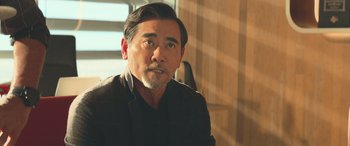 Movie still from “The Meg” (2018), directed by Jon Turteltaub – A person wearing a suit; Close Up shot, Over the shoulder angle