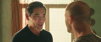 Movie still from “The Meg” (2018), directed by Jon Turteltaub – A man talking to another man in front of a window; Close Up shot, Over the shoulder angle