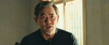 Movie still from “The Meg” (2018), directed by Jon Turteltaub – An older man with a beard looking at the camera; Close Up shot, Over the shoulder angle