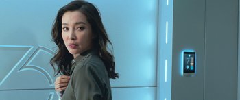 Movie still from “The Meg” (2018), directed by Jon Turteltaub – A woman with long black hair standing in front of a blue wall; Close Up shot, Low angle