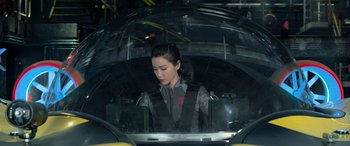 Movie still from “The Meg” (2018), directed by Jon Turteltaub – A woman sitting inside of an airplane cockpit; Medium shot, High angle