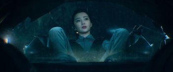 Movie still from “The Meg” (2018), directed by Jon Turteltaub – A woman sitting in the back seat of a car at night; Medium shot, Low angle
