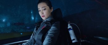 Movie still from “The Meg” (2018), directed by Jon Turteltaub – A woman in a car with a backpack on her back; Medium shot, Over the shoulder angle