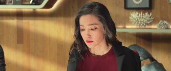 Movie still from “The Meg” (2018), directed by Jon Turteltaub – A woman with long black hair wearing a red shirt and a black jacket; Close Up shot, High angle