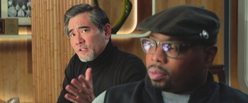 Movie still from “The Meg” (2018), directed by Jon Turteltaub – Two men sitting in front of each other in a room; Close Up shot, Over the shoulder angle