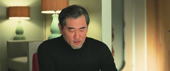 Movie still from “The Meg” (2018), directed by Jon Turteltaub – An older man in a black shirt is looking down; Close Up shot, Over the shoulder angle