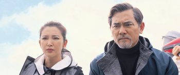 Movie still from “The Meg” (2018), directed by Jon Turteltaub – A man and a woman standing next to each other in front of a cloudy sky; Close Up shot, Low angle