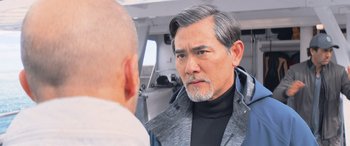 Movie still from “The Meg” (2018), directed by Jon Turteltaub – An older man looking at a younger man in the mirror; Close Up shot, Over the shoulder angle