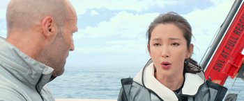 Movie still from “The Meg” (2018), directed by Jon Turteltaub – A woman standing next to a man on the beach; Close Up shot, Over the shoulder angle