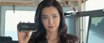 Movie still from “The Meg” (2018), directed by Jon Turteltaub – A beautiful young woman holding a cell phone; Close Up shot, Low angle