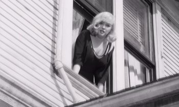 Movie still from “The Misfits” (1961), directed by John Huston – A black - and - white photo of a woman looking out of a window; Medium shot, Low angle