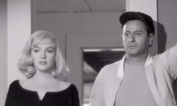Movie still from “The Misfits” (1961), directed by John Huston – A black and white photo of a man and a woman; Medium shot, Over the shoulder angle