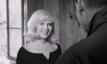 Movie still from “The Misfits” (1961), directed by John Huston – A black and white photo of a woman smiling; Close Up shot, Over the shoulder angle